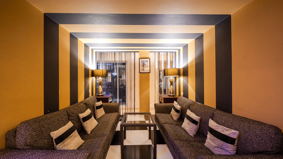 An illuminated bar at MGM Mark Whitefield, featuring cushions, pillows, and checkered floor.