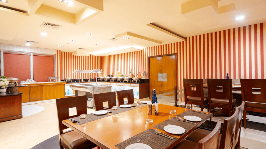 A dining space at MGM Mark Whitefield, featuring chairs, tables, and checkered wall.
