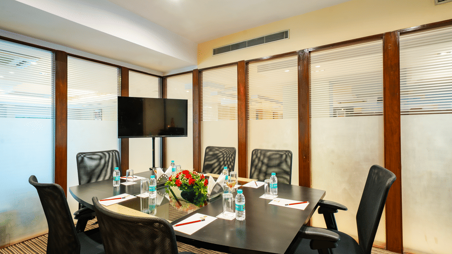 A meeting room with a television, chairs, and a table set for a meeting. |  MGM Mark Whitefield