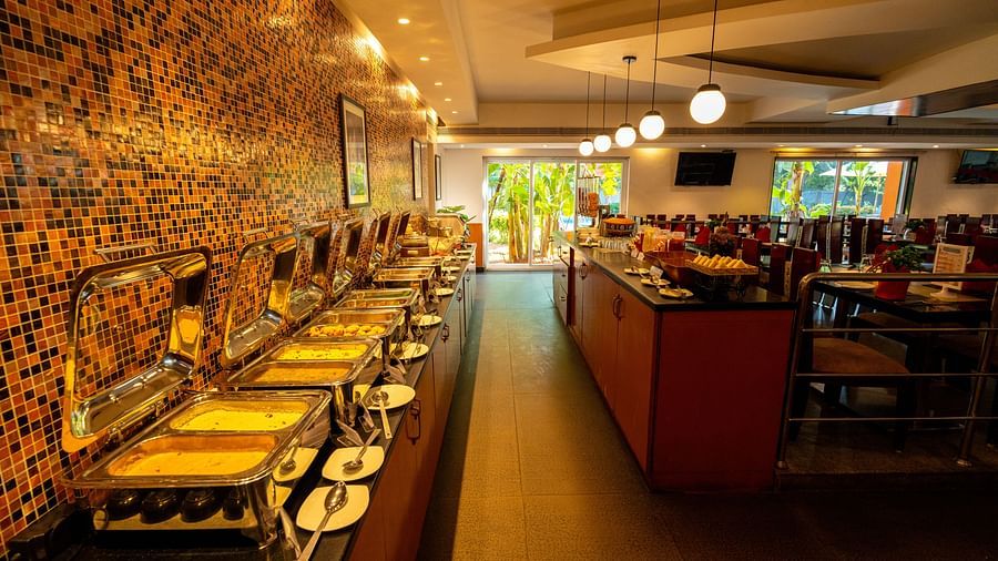 Image of restaurant featuring buffet counter with food under warm ambience