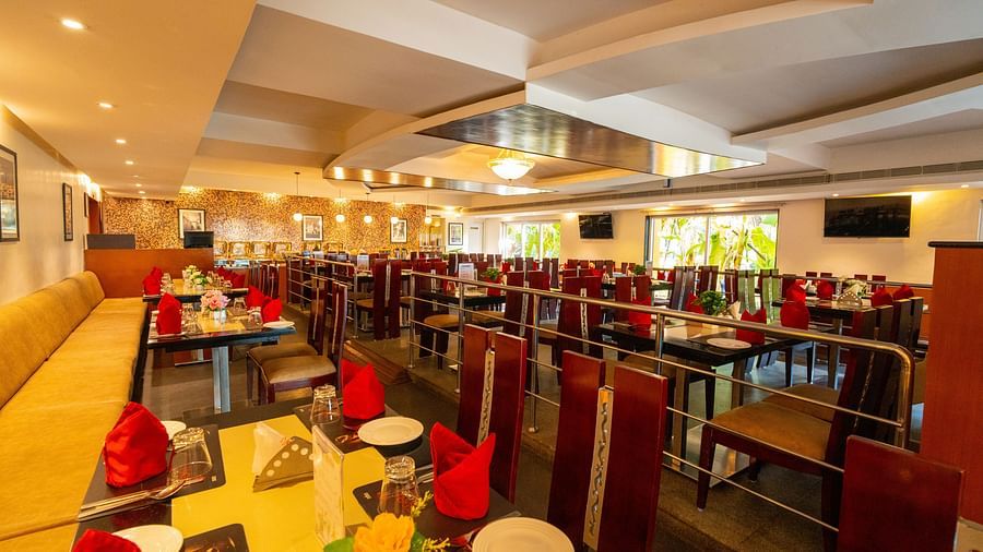 Image of restaurant featuring sets of dining chairs and  tables organised with cutlery