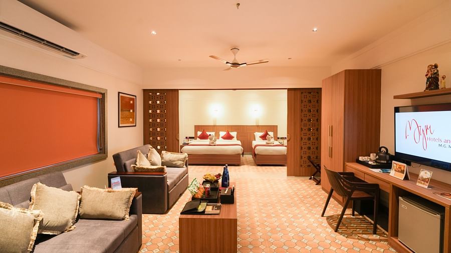 Image featuring partition between the living room and bedroom featuring sofa-cum-beds with coffee table in living room facing the TV and a double bed and a single bed in the bedroom