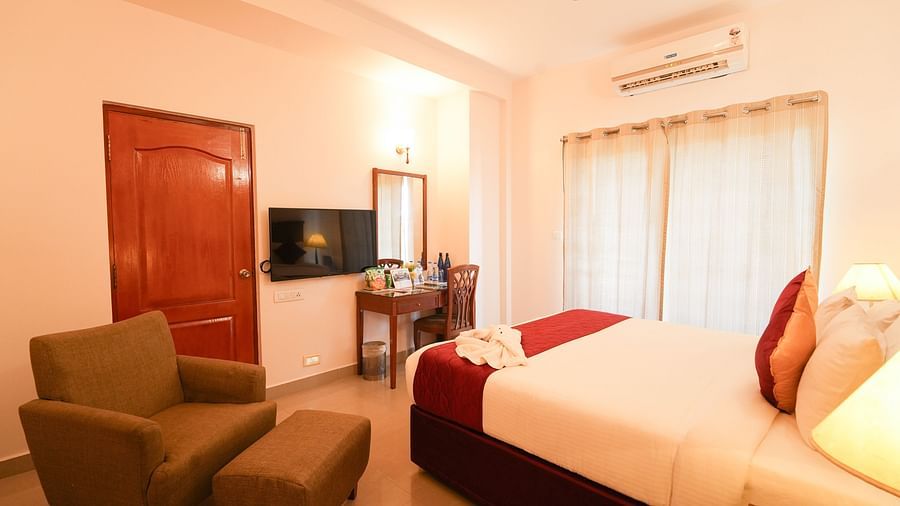 Grandeur Room featuring a bed facing a TV mounted on the wall