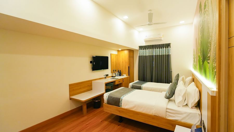 Image of twin bed facing the TV mounted on the wall in front of them