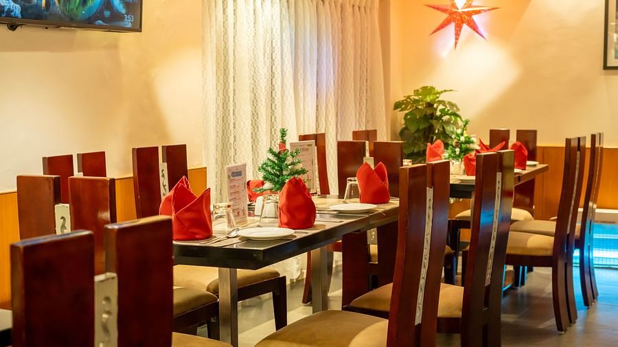 Image of restaurant minimally decorated for Christmas with mini Christmas trees placed on each table