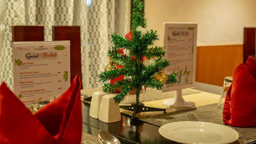 A close-up of the mini Christmas tree placed on a dining table next to which the special menu is displayed