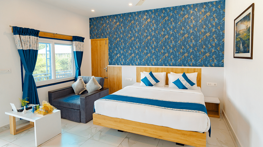 A cosy room with a comfortable double bed, good interiors and a sofa on the side- MGM Whispering Wind's Resorts