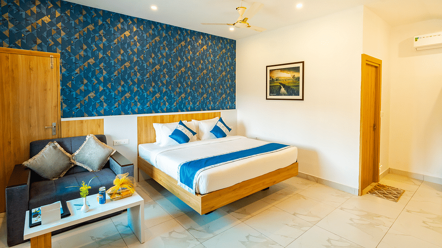  A room with a neatly arranged double bed, a sofa and a coffee table - MGM Whispering Wind's Resorts