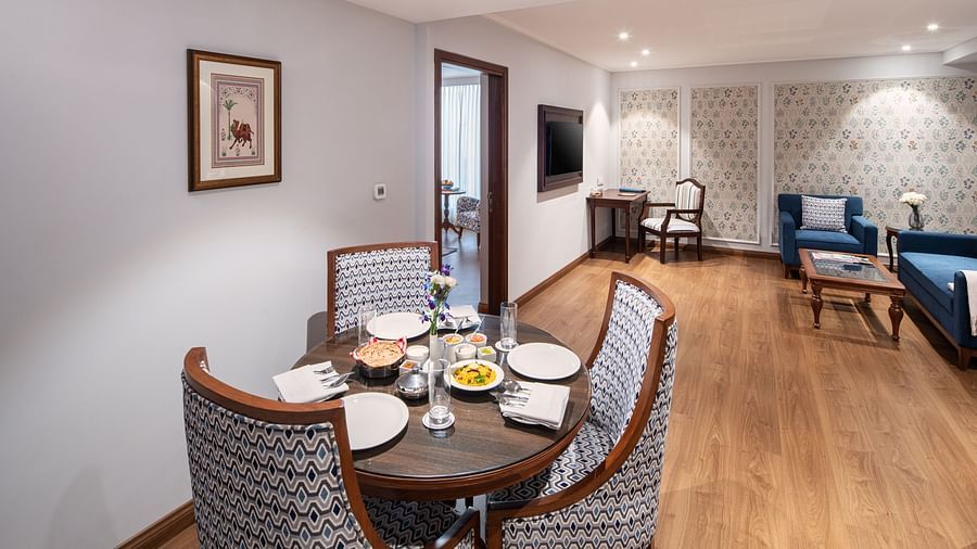 A round table set with food in the living room of our suite in Haridwar - MJ Sarovar Portico, Haridwar