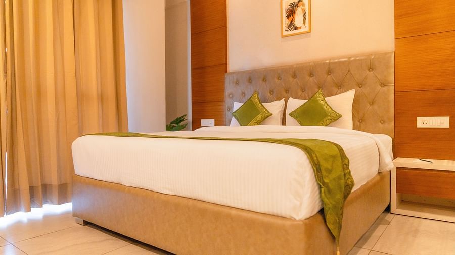 A large bed in a Deluxe Room at Montclair Ananta, Elite.