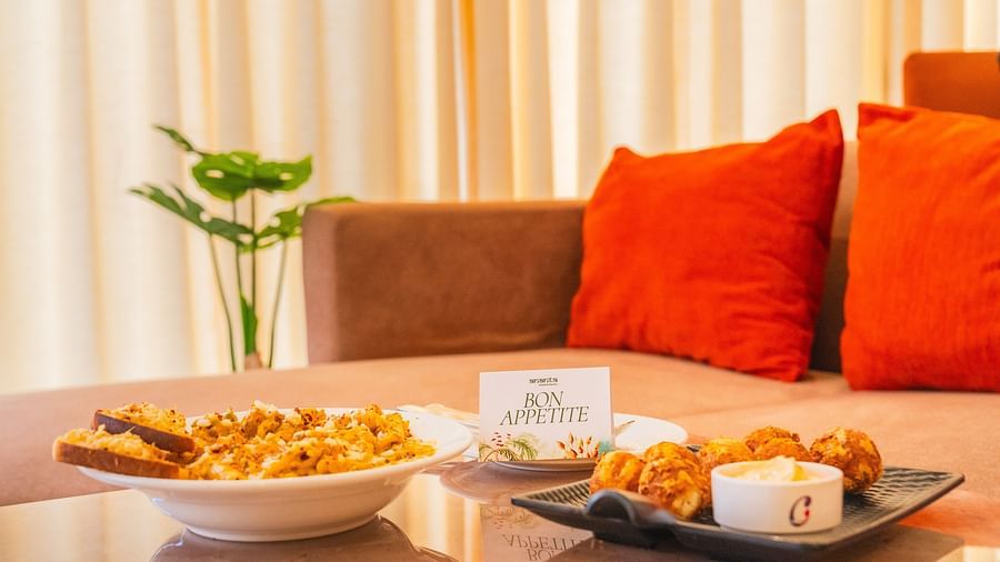 Eateries placed on a table in front of a sofa of a room at Montclair Ananta, Elite,