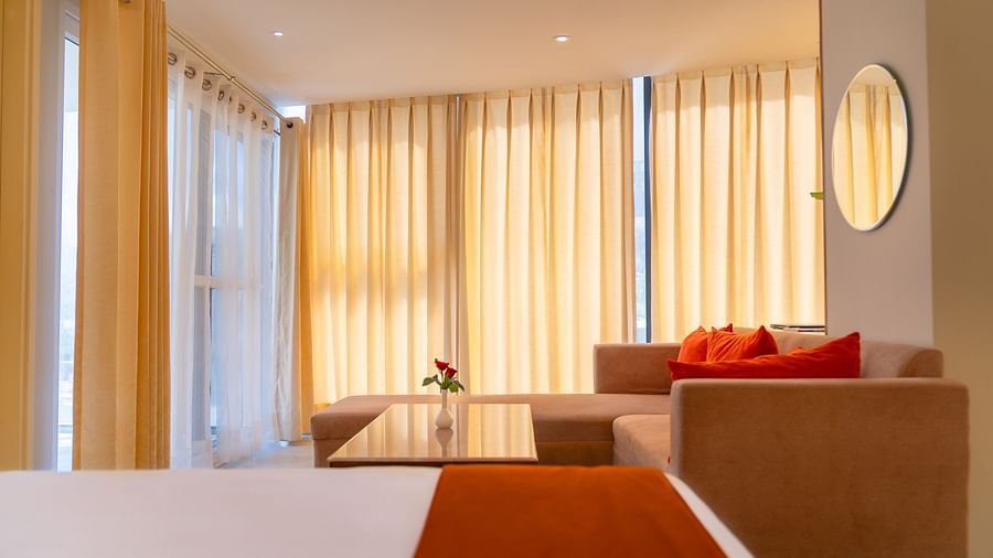 A view of the sofas from the bed of a Standard Room at Montclair Ananta, Elite.