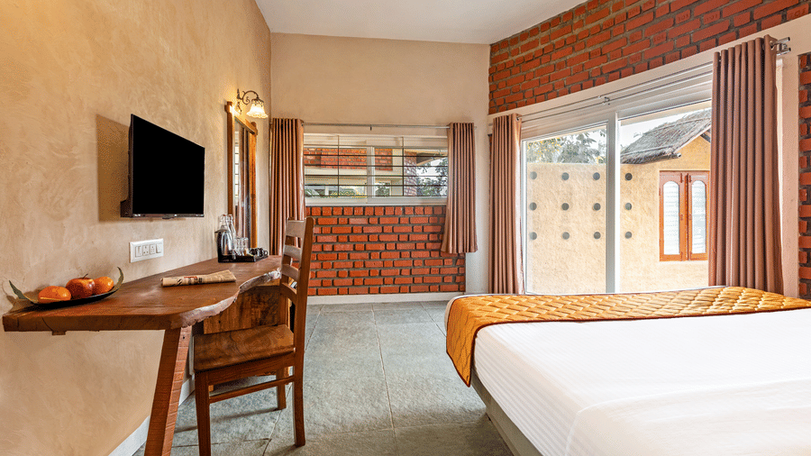 Perspective shot of a suite bedroom highlighting the natural light from the balcony - Nature Trails Ashoka Resort Hampi