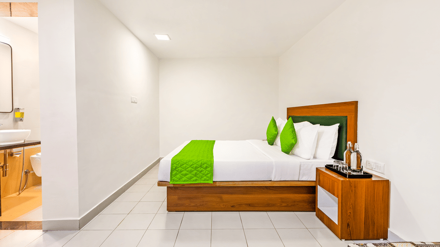 large bed with a wooden frame and matching headboard. The bed is made with white linens and a distinctive bright runner across the foot at Nature Trails Durshet.