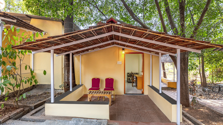 porch area with a ramp and a set of red chairs near the entrance.