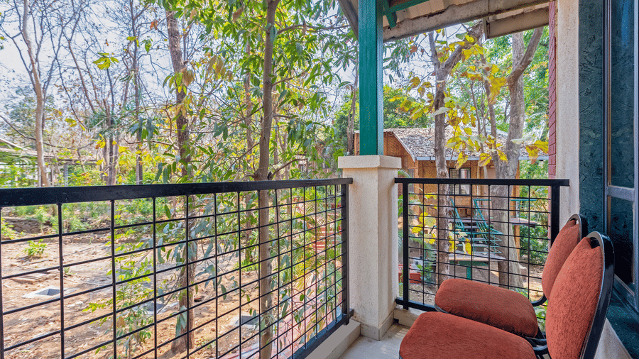 Classic room balcony with chairs, railing, and lush greenery view creating a relaxing outdoor space.