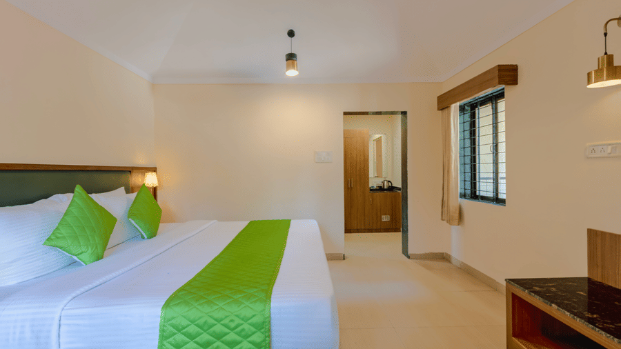 Full view of a classic room featuring a double bed, desk, and clean spacious layout.