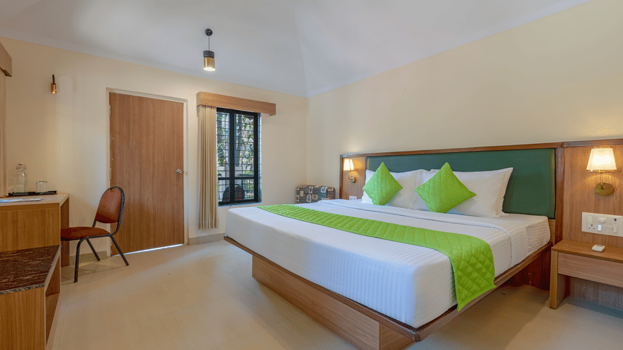 Classic room bedroom with a double bed, wooden furniture, desk, and well-lit spacious interior.