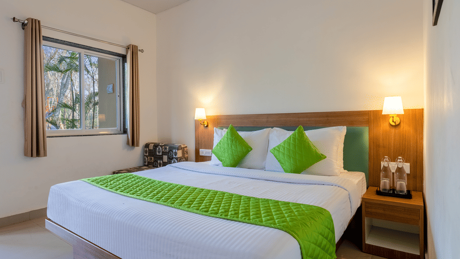 Bedroom with a double bed, bedside table, and window view bringing in natural light.