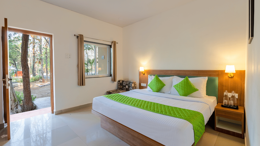 Spacious bedroom with a double bed, seating chair, side table, and large open area.