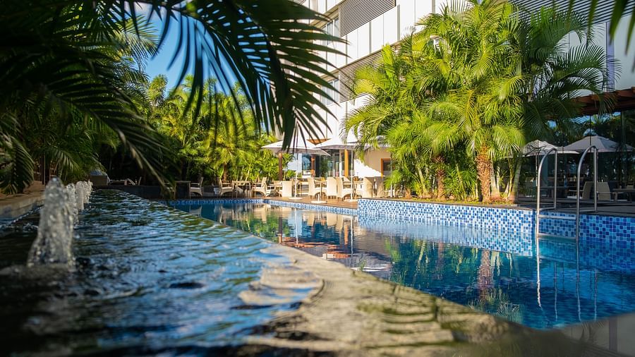 A picturesque view of the swimming pool surrounded by greenery at Neelkanth Sarovar Premiere Lusaka