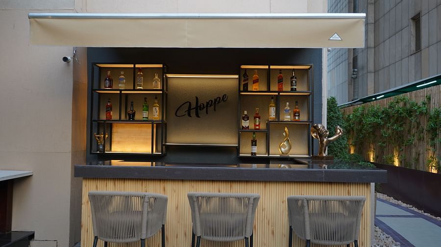 Nemesia provides an outdoor bar area with an awning, shelves, a counter, and stools.