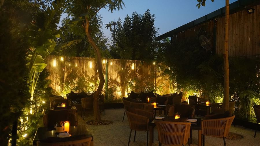 Nemesia offers an outdoor dining area with tables and chairs illuminated by string lights.