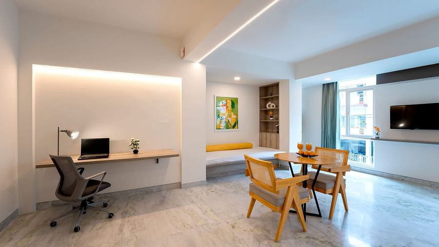 Corner workspace with table, lamp and desk setup at Nest by Rivido Apart Hotel, Bannerghatta Road