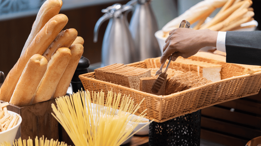 A buffet display at Nirvana Sarovar Portico, Gorakhpur featuring fresh baguettes, bread baskets, and pasta options.