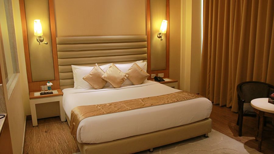 a warm-lit room featuring plush bed with two nightstands on both sides