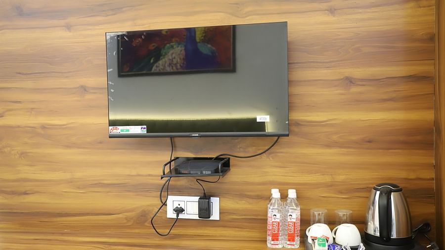 A picture of a LED TV water bottles cups and a kettle