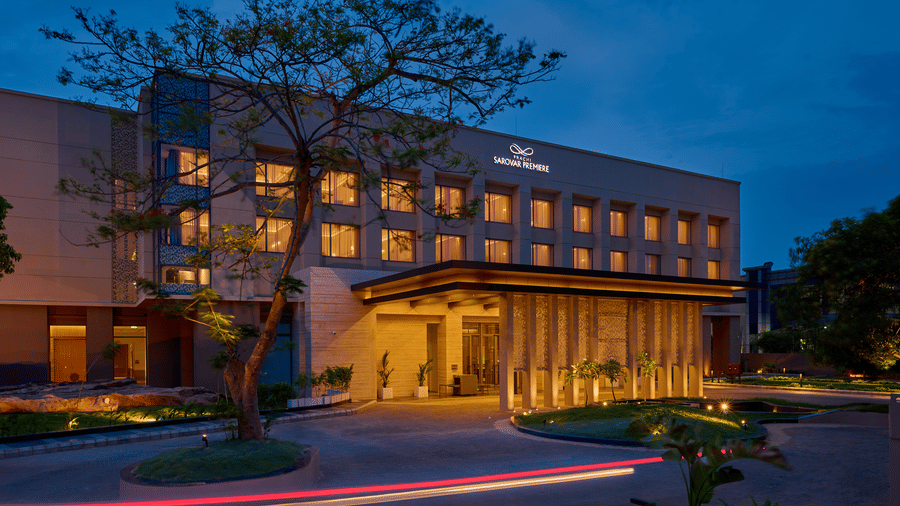 Exterior view of Prachi Sarovar Premiere, Bhubaneswar, showing the lit facade and entrance canopy of the multi-storey hotel building at dusk.