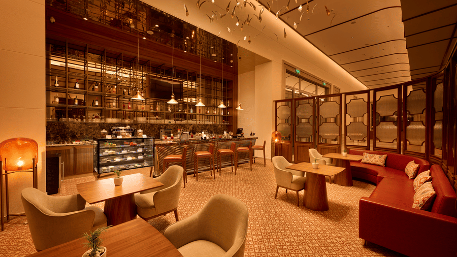 Mahua Bar at Prachi Sarovar Premiere, Bhubaneswar, with tables, armchairs, a display counter, bar stools, and a long sofa arrangement.