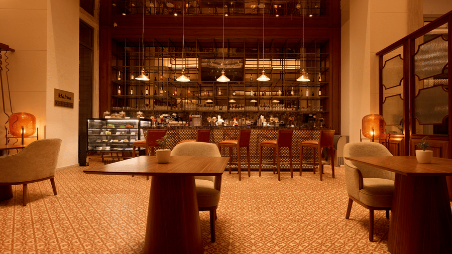 Mahua Bar at Prachi Sarovar Premiere, Bhubaneswar, featuring wooden tables, seating, patterned tiling, and a food display case under warm lights.