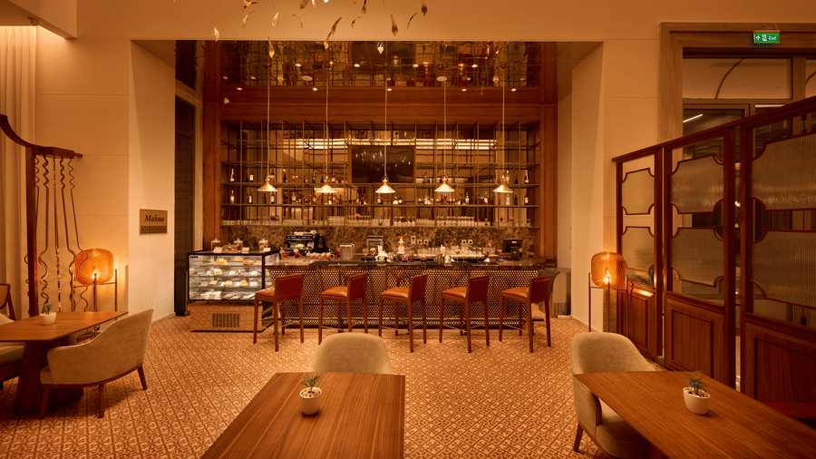 Mahua Bar at Prachi Sarovar Premiere, Bhubaneswar, with tables, armchairs, a bar counter with stools, and decorative screen panels.