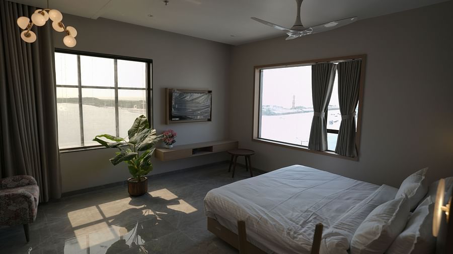 Deluxe Room at Pride Comfort, Dwarka with a double bed and view of the city from the windows