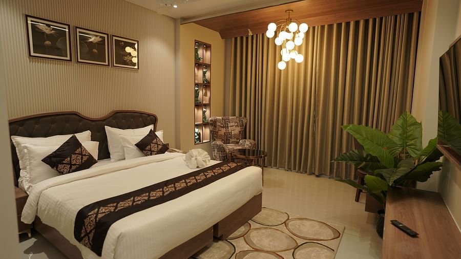 Executive Suite Room at Pride Comfort, Dwarka with a double bed, a television and a chandelier