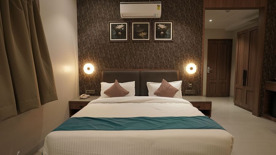 Premium Room at Pride Comfort, Dwarka with a double bed and side tables