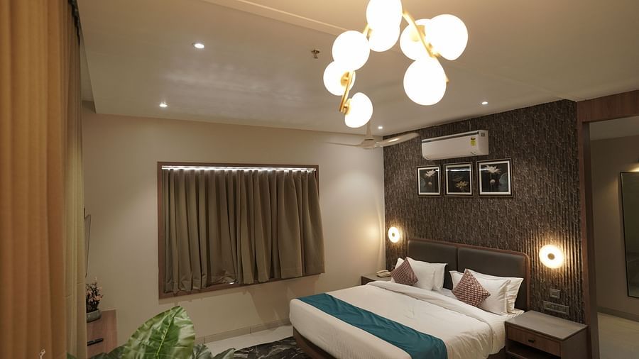 Premium Room at Pride Comfort, Dwarka with a double bed and a chandelier
