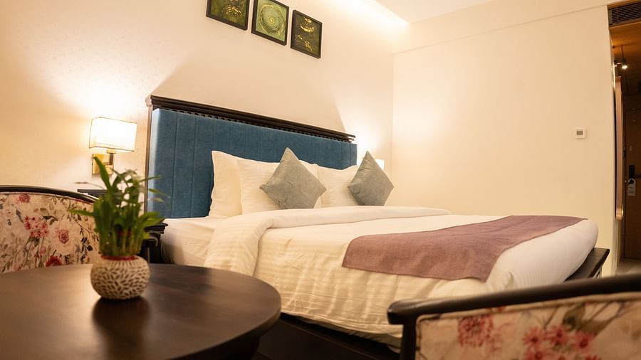 Image of Deluxe Room with bed and table beside the bed at Pride Elite Daman.