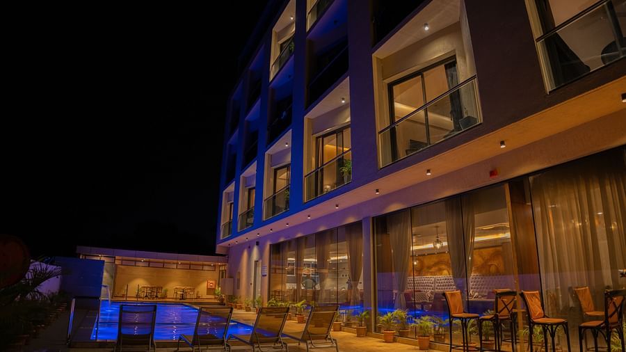 Night facade of Pride Elite Daman with chiars placed outside.