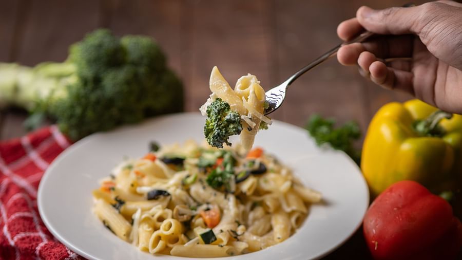 Image of a plate of pasta with vegetables on the side of the plate at Pride Elite Daman.
