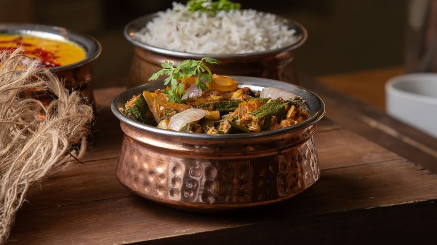 Image of a bowl of currry and a bowl with rice behind at Pride Elite Daman.