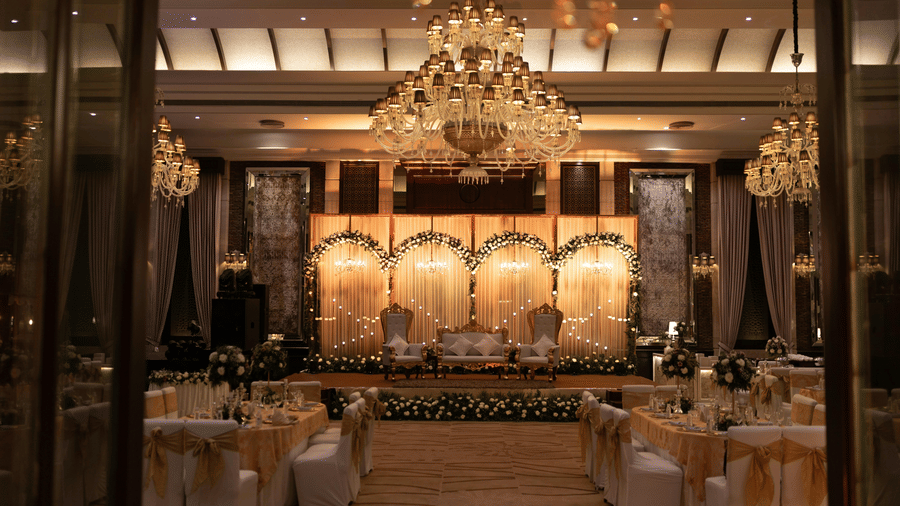 Grand wedding stage and banquet hall with crystal chandeliers.