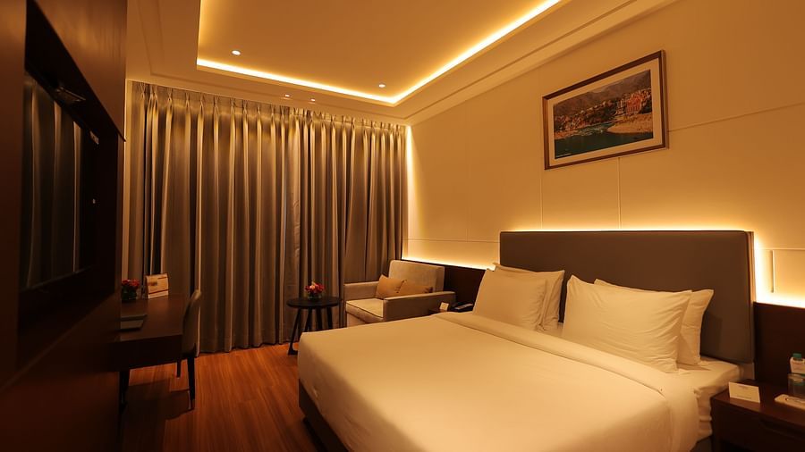 view of the king size bed with comfortable sofas of Deluxe Room at Pride Elite, Haridwar