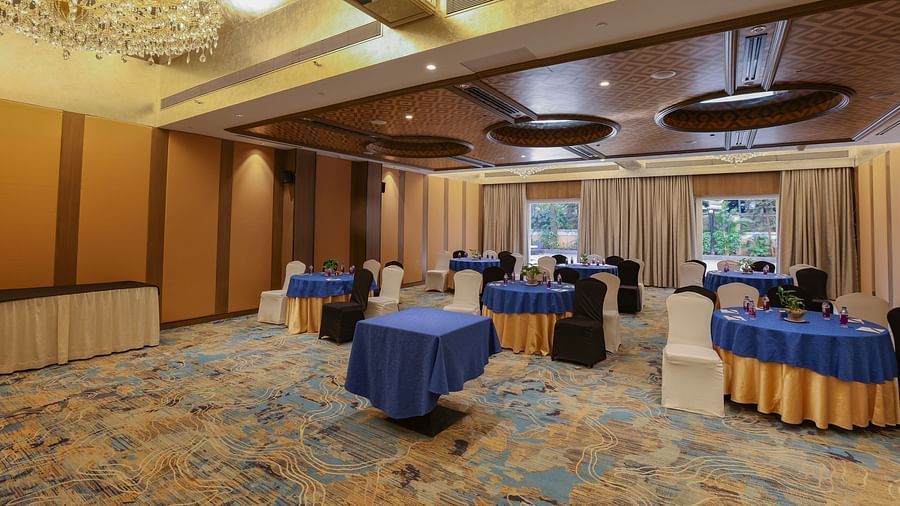 A room with tables and chairs, possibly set up for a meeting or event - Pride Hotel Pune
