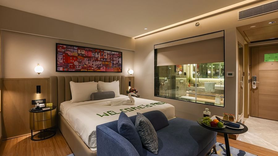 A hotel room with a bed and a view of the outside - Pride Hotel Pune