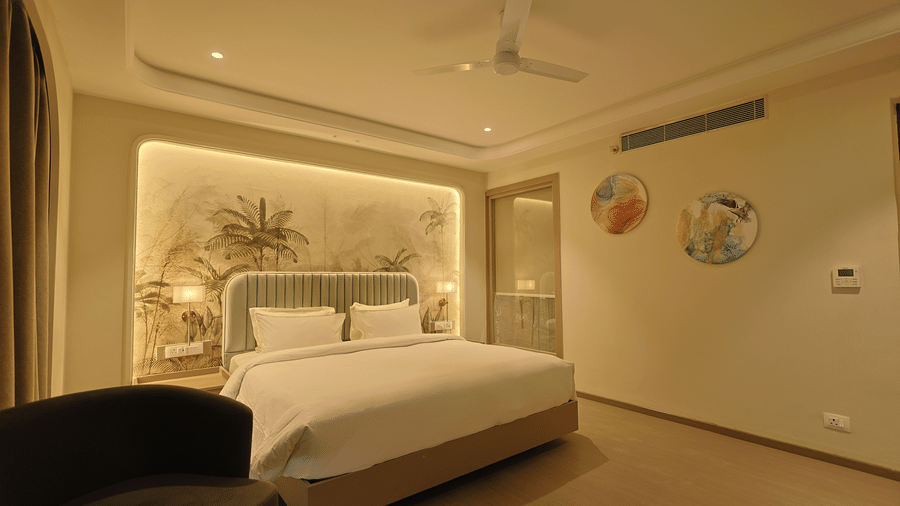 Pride Premier Alwar | A room with a large bed, spreads, pillows, and a cushion.