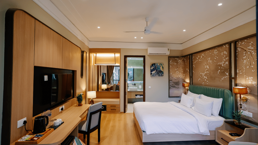 Pride Premier Alwar | A room with a large bed, bedspreads, pillows, a television, and mirrors