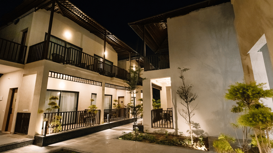 Pride Premier Alwar | A facade with the balcony of cottages with plants at night.